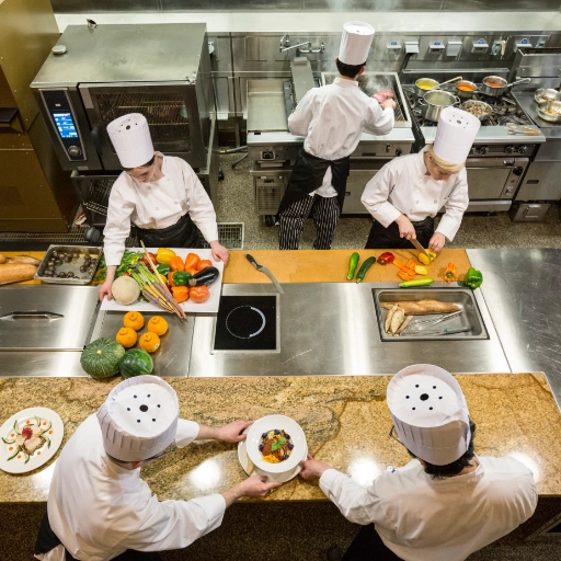 équipe de cuisiniers professionnels en train de couper des légumes