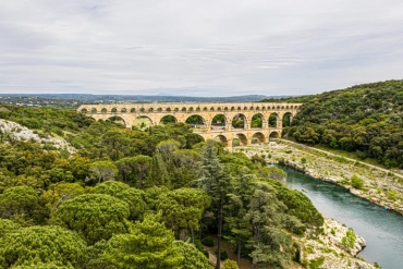 frigoriste et climaticien pont du gard nîmes Pont aqueduc romain traversant la rivière et forêt verdoyante.